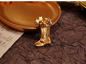 Detailansicht einer vintage metallenen stiefelförmigen brosche mit sicherer nadel auf teller.