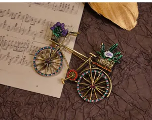 Detailansicht der Vintage Fahrrad Brosche mit feinen Strasssteinen und Blumenkorb Dekoration.