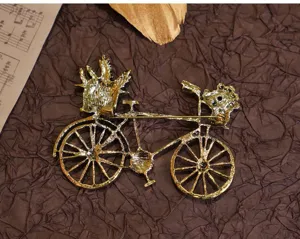 Exquisite Vintage Fahrrad Brosche mit zarten Blumen Details und elegantem goldfarbenem Finish.