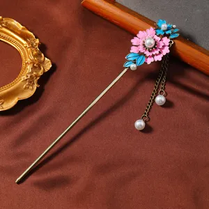 Primo piano di un fermaglio per capelli floreale smaltato in stile cinese con perle e catene.