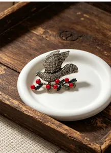 Vintage rhinestone peace dove brooch pin with red berries, elegant coat accessory for women.