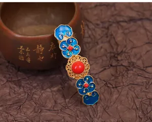 Detail van cloisonne haarspeld, retro blauw emaille bloemmotief met rode kralen accenten.