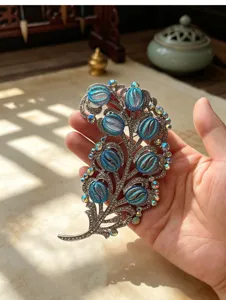 Exquisite vintage court style feather brooch with sparkling crystals and blue cabochons for women.