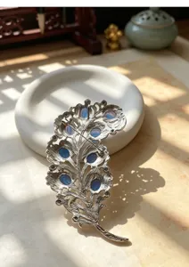Vintage palace style feather brooch, detailed metal carving with blue stones for coat.