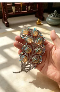 Vintage feather brooch with iridescent cabochons and dazzling rhinestones for luxury wear.