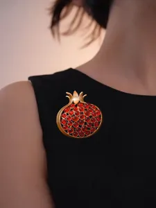 Vintage matte gold pomegranate brooch detailed shot, elegant red stone crystal pin for women suit.