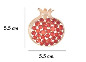 Detailed shot of the vintage matte gold pomegranate brooch featuring vibrant red rhinestone accents.