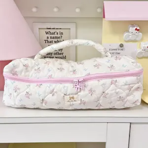 Vista dettagliata della borsa trapuntata a fiori per strumenti per capelli rosa.