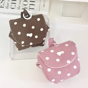 Detailansicht eines süßen koreanischen Polka-Dot-Kosmetikbeutels mit Herzknopf und Aufhängung.