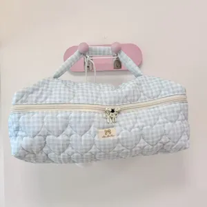 Dettaglio di borsa portaoggetti trapuntata a quadri blu, elegante trousse da viaggio.