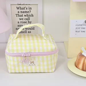 Detailansicht der gelben karierten Kosmetiktasche mit Reißverschluss und niedlicher Schleife.
