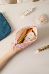 Close-up of a pink corduroy cosmetic bag with zipper, perfect for daily travel storage.