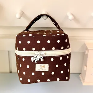 Bruine cosmetische tas polkadot gedetailleerd weergave met schattige strik trekker