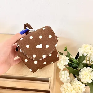 Detaillierte Nahaufnahme einer braunen Kosmetiktasche mit weißen Punkten und Herz.