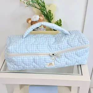 Dettaglio borsa portaoggetti trapuntata a quadri blu, organizer da viaggio per accessori.