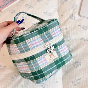 Grüner karierter Kosmetiktasche Detail mit Reißverschluss, Schleifengriff und Tragegriff.