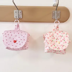Detailed view of cute fabric storage pouches hanging on hook, showing sweet patterns and snap.