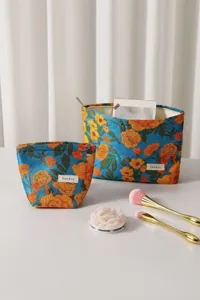 Vista di dettaglio della borsa cosmetica in tessuto jacquard floreale blu stile vintage.