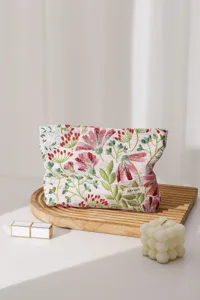 Detailed close-up of floral embroidered cosmetic bag with lovely cosmos pattern and zip.