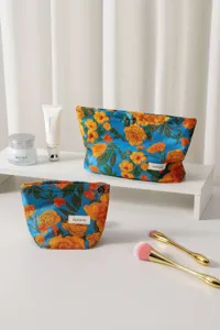 Primo piano sul dettaglio della borsa cosmetica in jacquard floreale, elegante pochette blu.