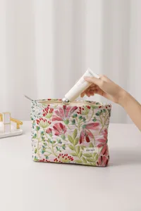 Detailed view of fabric cosmetic bag with floral embroidery and secure zipper closure.