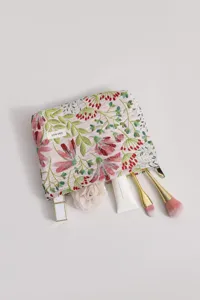 Floral embroidered fabric cosmetic bag detail showing zipper closure and storage capacity.
