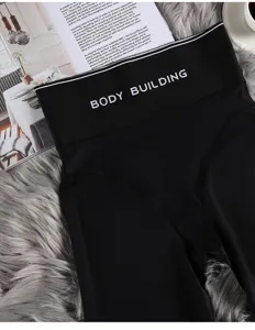 Detailed close-up of black high-waisted shaping pants waistband with fitness print.