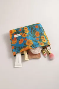 Dettaglio della borsa cosmetica vintage in jacquard floreale, elegante organizer per trucco.