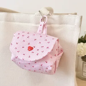 Close-up detail of the pink striped cherry print mini storage pouch with heart button and chain.