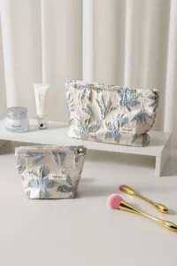 Detail view of the floral jacquard cosmetic makeup bag, featuring elegant blue and gold pattern.