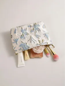 Chic gold-threaded jacquard cosmetic bag with secure zipper, stylish portable makeup storage pouch.
