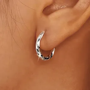Detailed view of silver twist hoop earring featuring a modern Möbius geometric design.