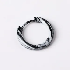 Close-up detail shot of the black and white swirled enamel hinged hoop earring surface.