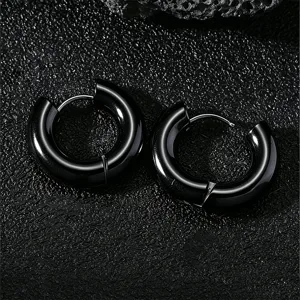 Gros plan de boucles d'oreilles créoles en acier inoxydable noir classique, surface lisse.