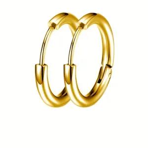 Gros plan détaillé de boucles d'oreilles créoles dorées minimalistes en acier.
