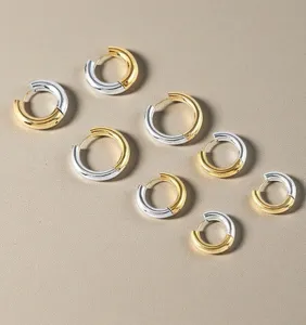 Two-tone stainless steel hoop earrings detail, geometric gold and silver color block design.