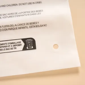 Transparent plastic packaging bag detail, clear safety warning prints and hang hole.