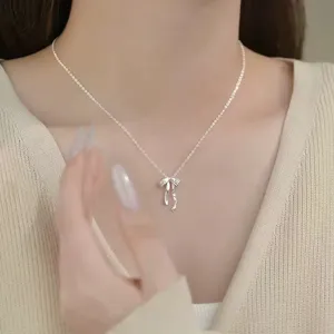 Detailed close-up view of the delicate silver bow pendant necklace showcasing fine metal texture.