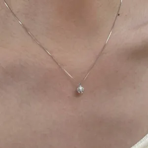 Detailed close-up view of S925 silver sparkly cubic zirconia pendant necklace worn on neck.