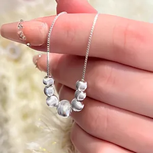 Detailed closeup of the sterling silver bead pendant necklace, showing delicate chain and texture.