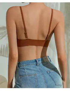 Back view detail of women's seamless strappy bra in brown, paired with denim shorts.