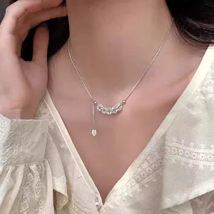 Detailed close-up shot of the delicate silver coin necklace, showcasing fine chain texture and pendants.
