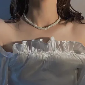 Gros plan détaillé du collier de perles multicouches, chaîne de clavette élégante au quotidien.