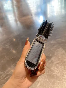 Detail close-up of the portable folding hair brush with built-in mirror and sparkling rhinestones.