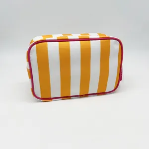 Detailed view of the striped toiletry bag, showcasing orange vertical patterns and pink trim.