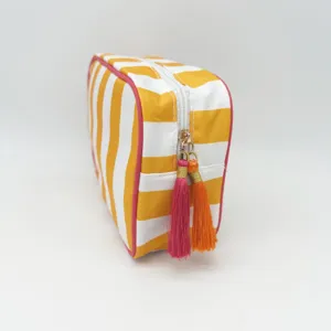 Yellow and white striped cosmetic bag with pink trim and colorful tassels for travel use.