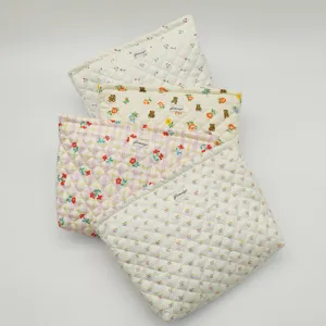 Detailed view of cute quilted cosmetic bags with floral and bear patterns for daily use.