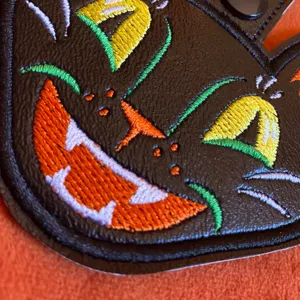 Close-up view of a cute Halloween black cat embroidery PU leather keychain charm detail.