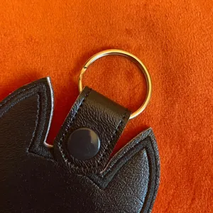 Black PU leather cat keychain detail view, portable bag charm pendant for women and girls.