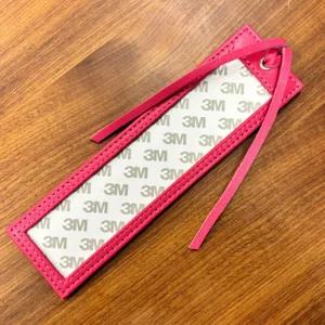 Pink PU leather cross stitch bookmark with tassel and adhesive backing for DIY craft.